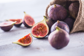A few figs freely lying on old wooden table.